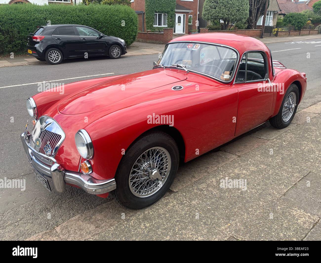 MG MGA red sports car bright British old classic posh old style Northampton Park Avenue UK shinny rear front side famous cars silver bumper - Smartphone Captured Stock Image