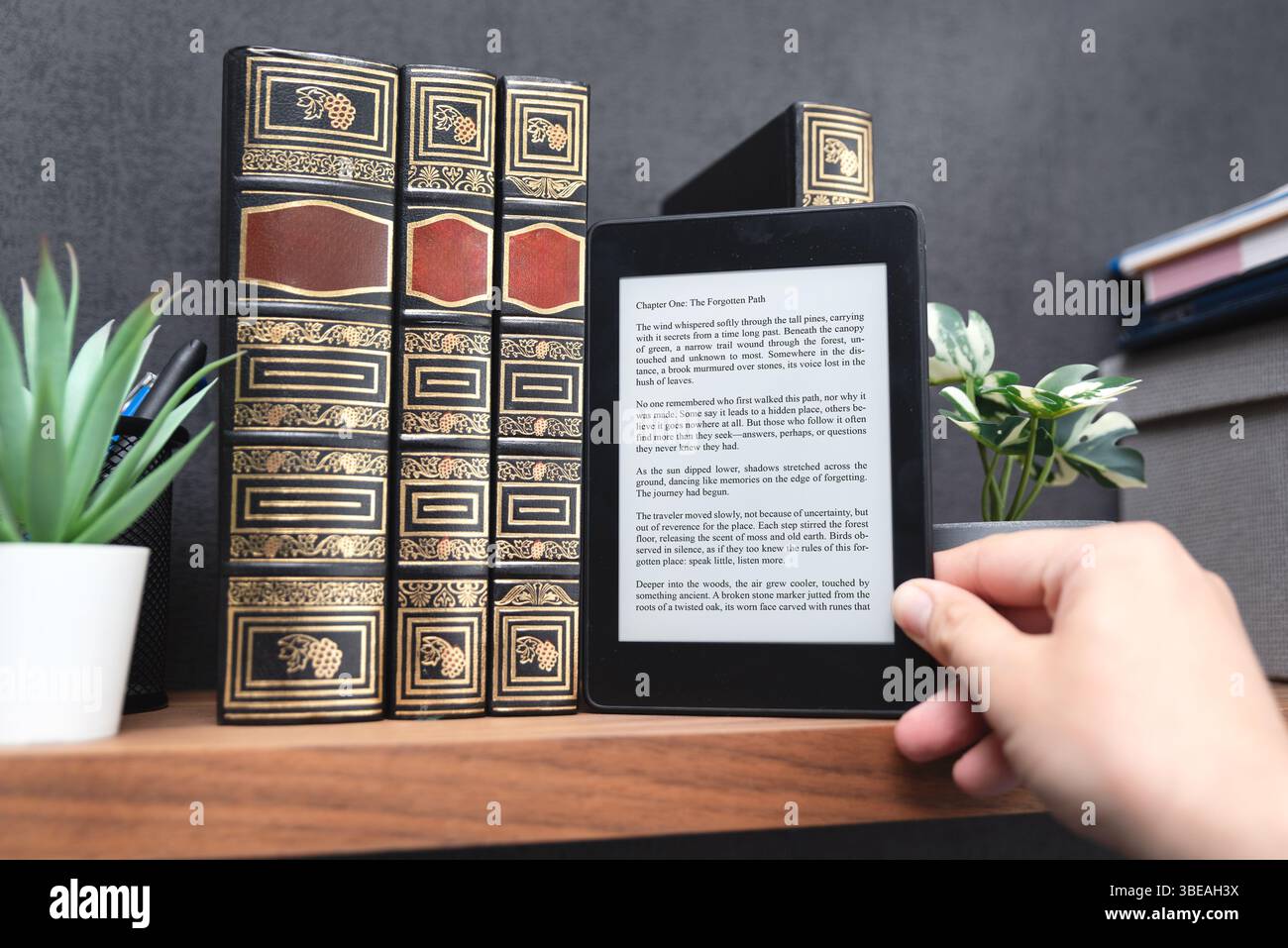 E-book reader device on shelf in home library Stock Photo