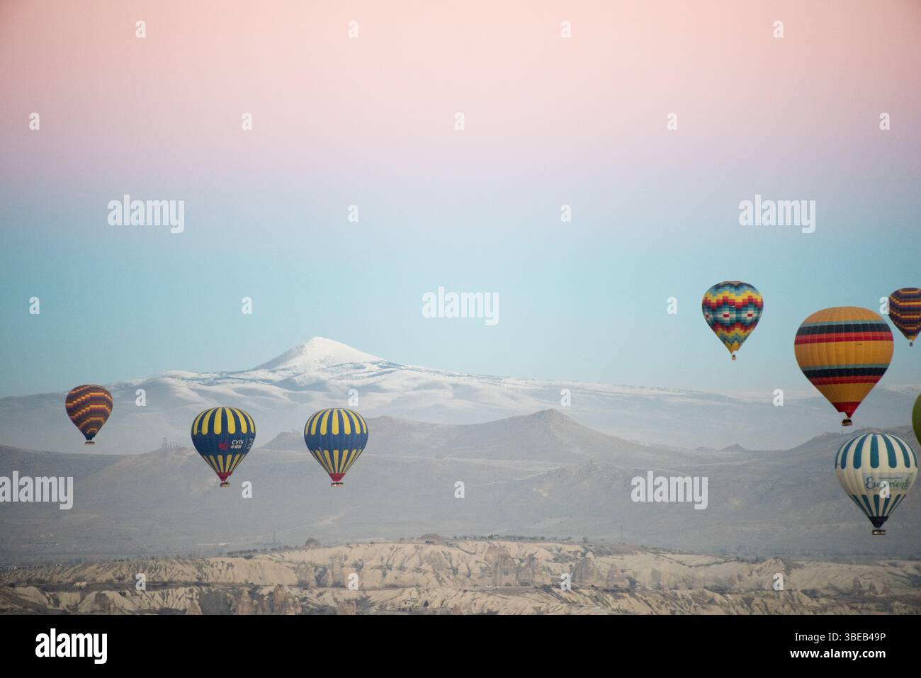Colorful hot air balloons ascend over Cappadocia as dawn breaks ...