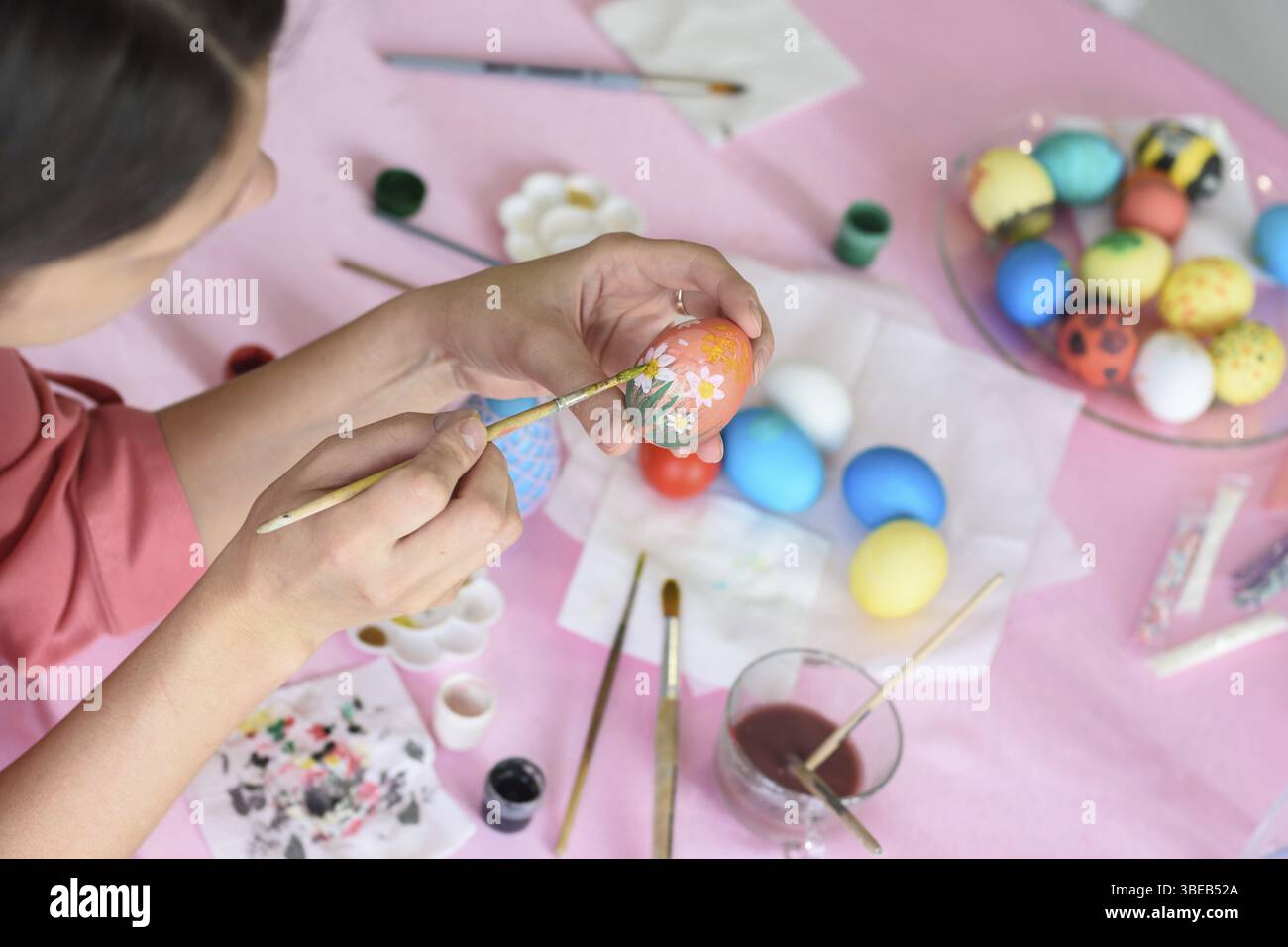 Girl paints chicken eggs for Easter Stock Photo