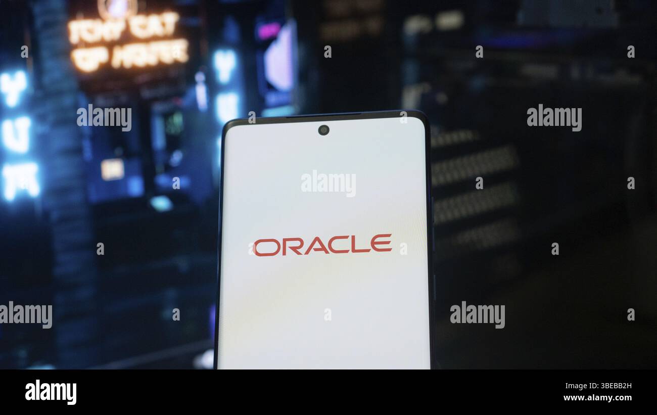 Smartphone displaying Oracle logo against a futuristic cityscape with ...