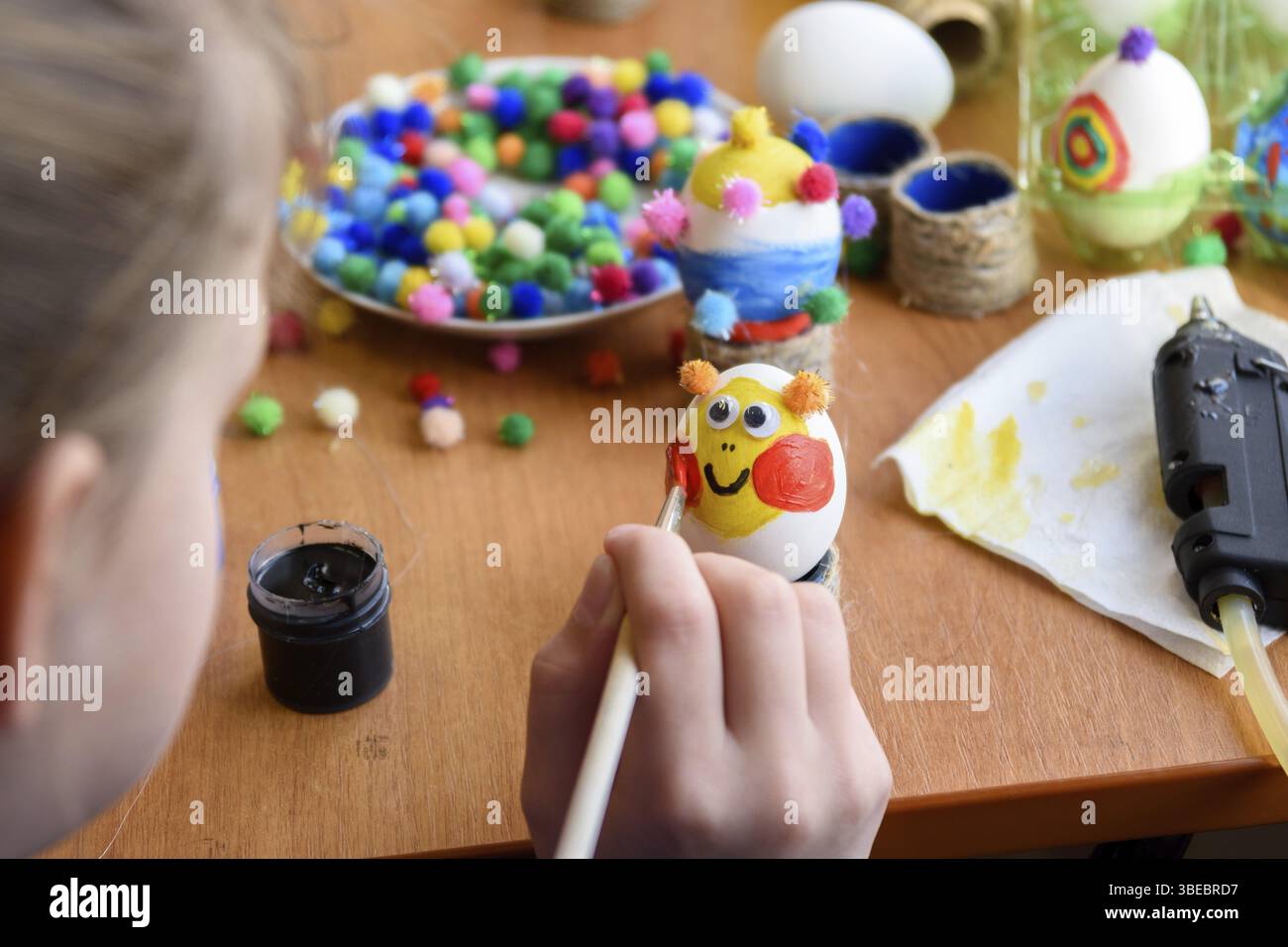 Girl beautifully paints Easter eggs Stock Photo