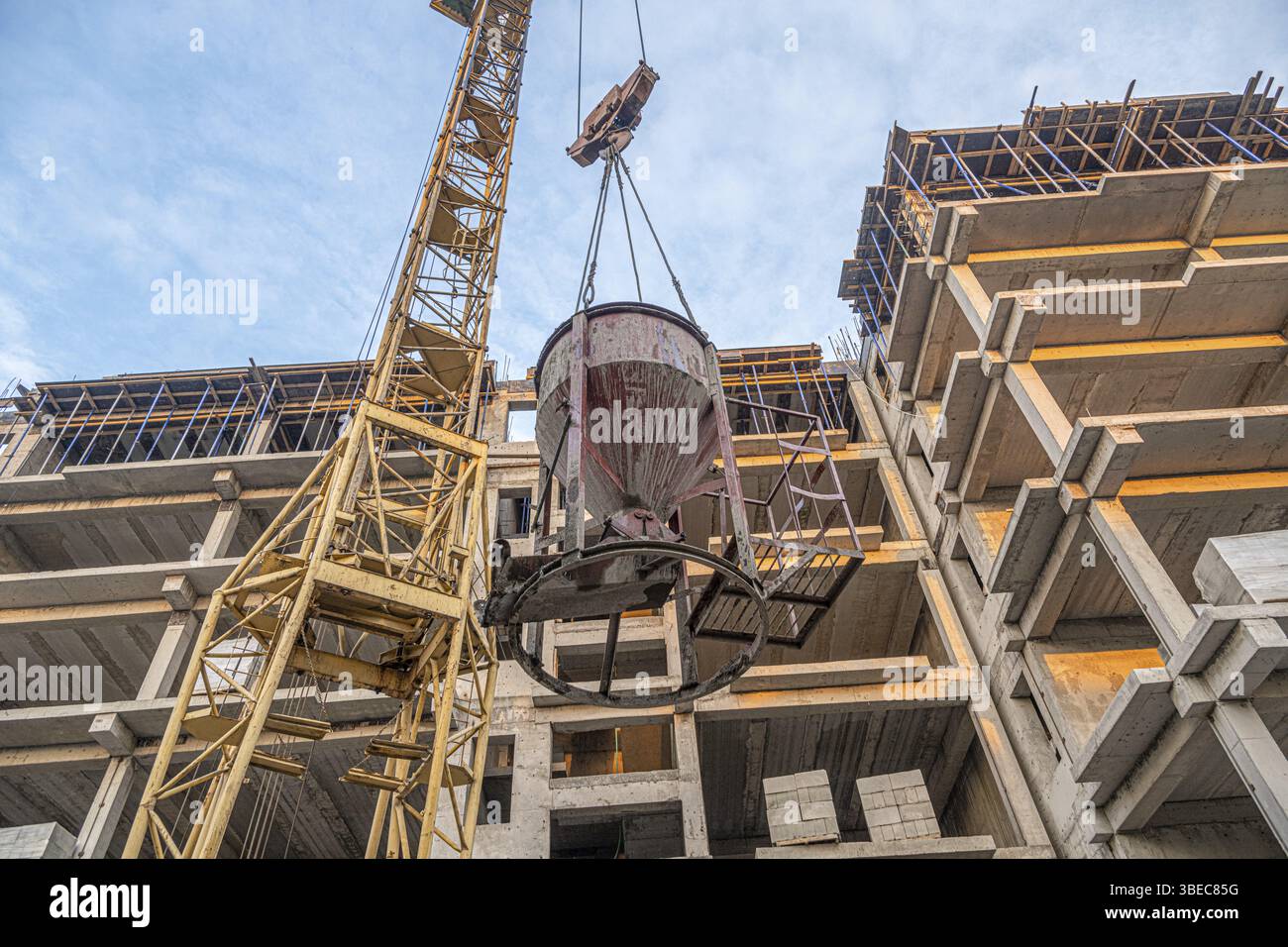 A low angle shot of a crane with equipment on a construction site with ...
