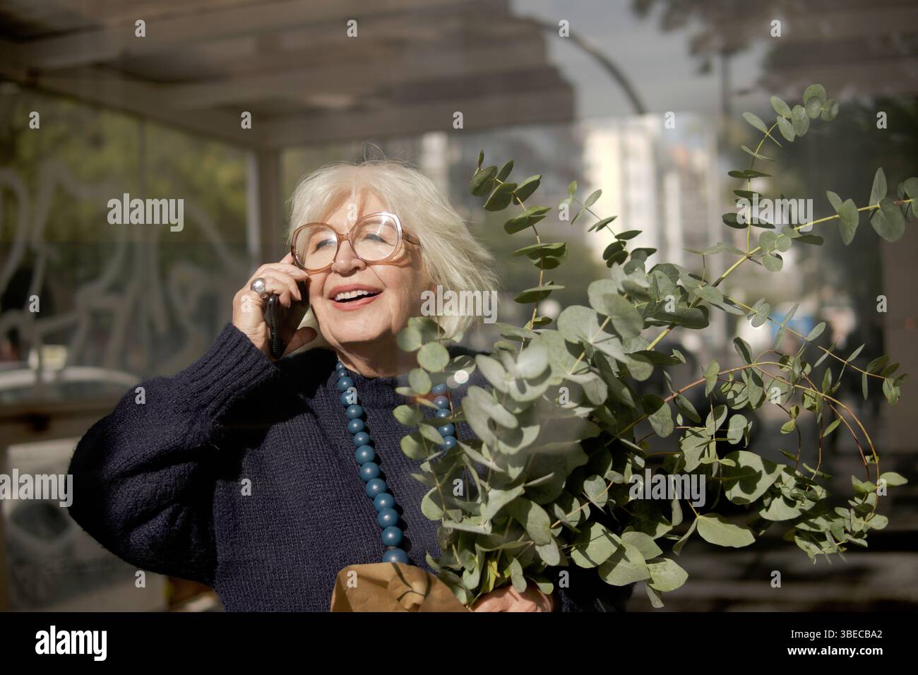 older woman talking on the phone outdoors Stock Photo