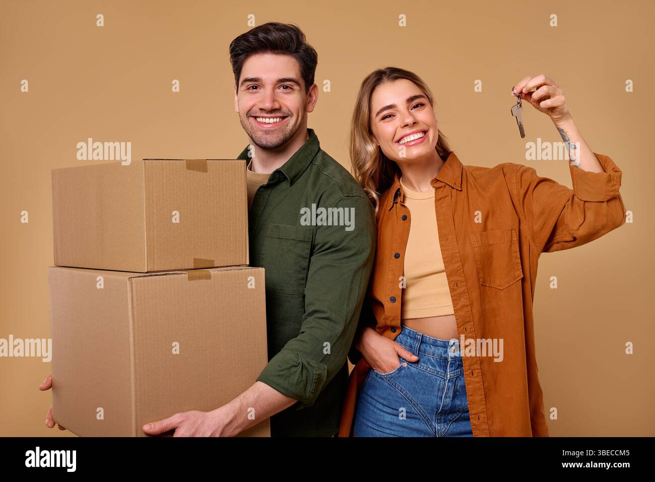 A joyful and happy young couple is celebrating their new home together ...