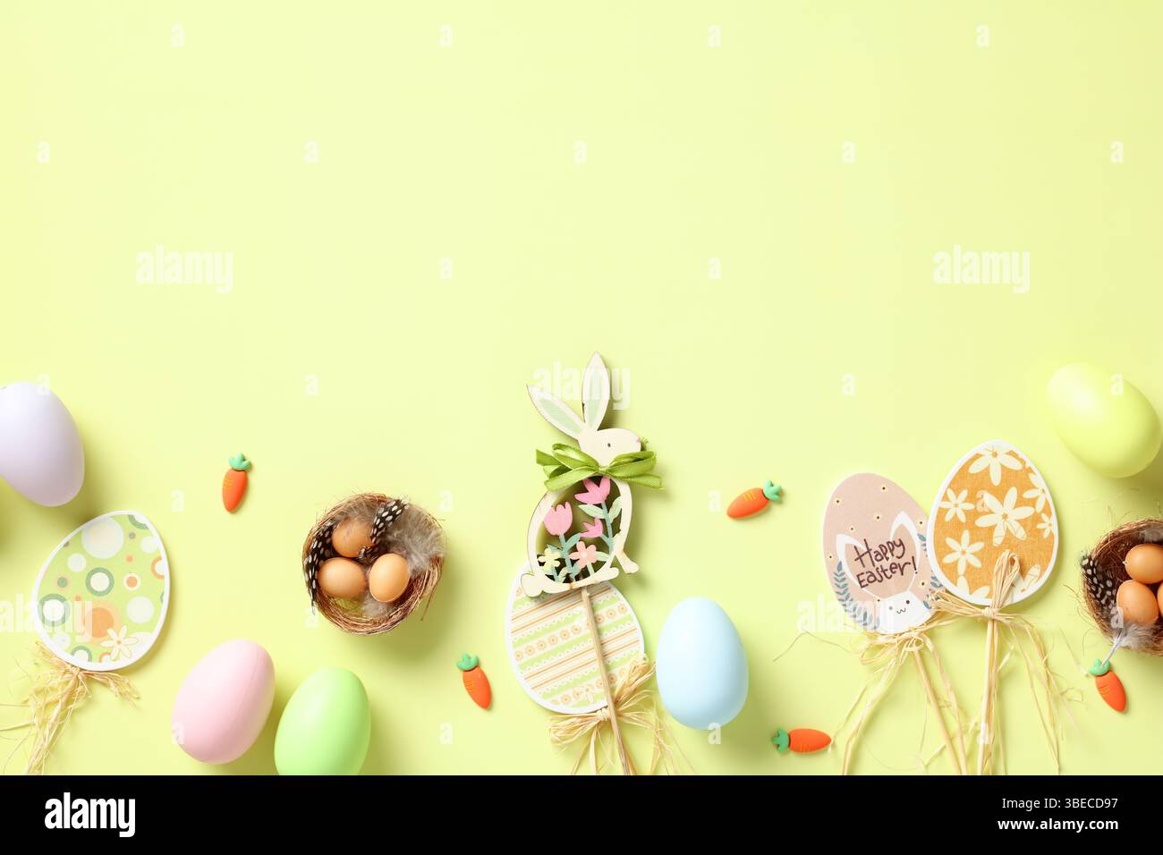 Happy Easter card. Flat lay Easter eggs, decorations, nest with eggs on green background. Top view. Stock Photo
