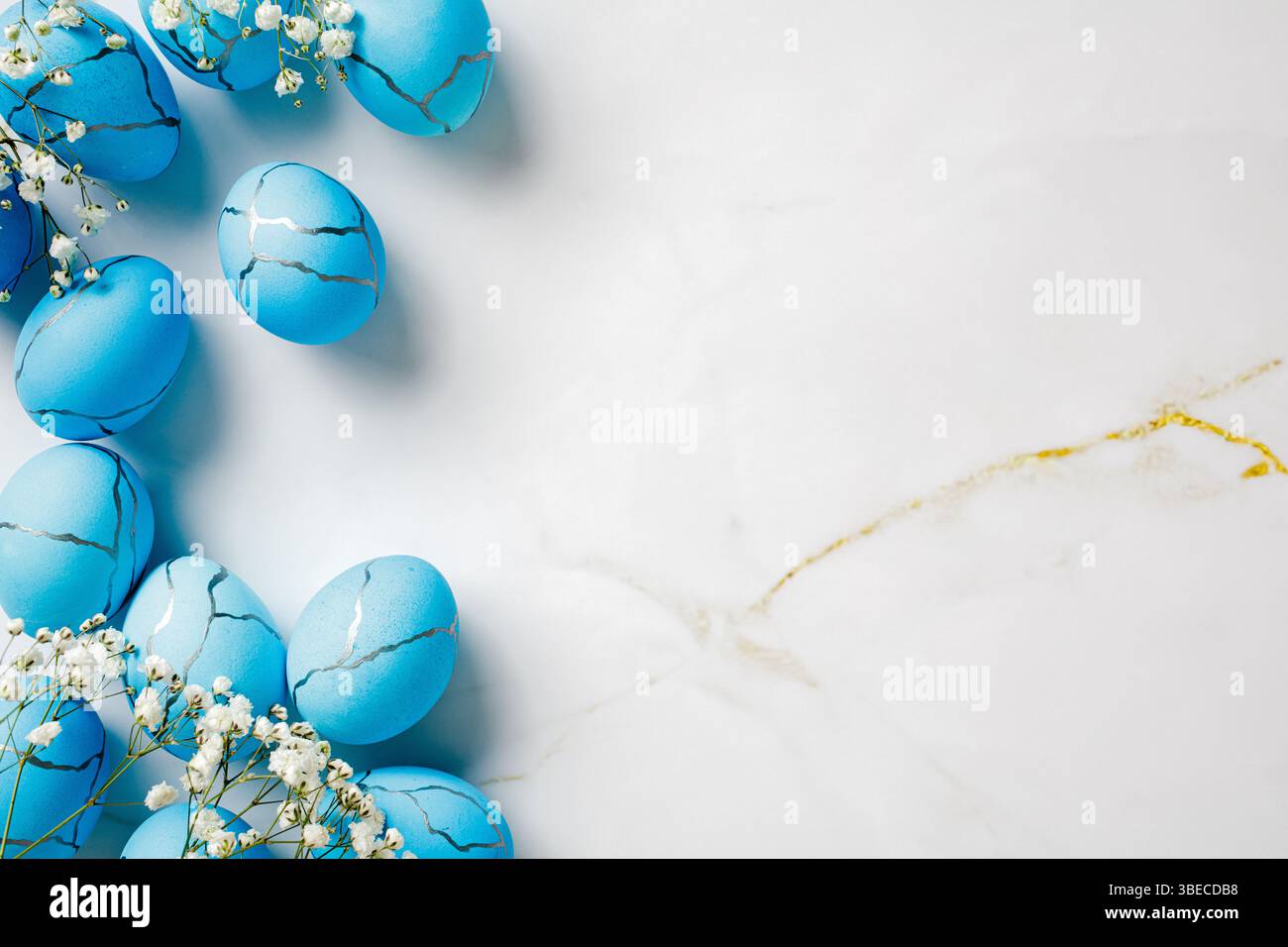 Flat lay composition with blue Easter eggs and flowers on marble stone table. Easter background. Stock Photo