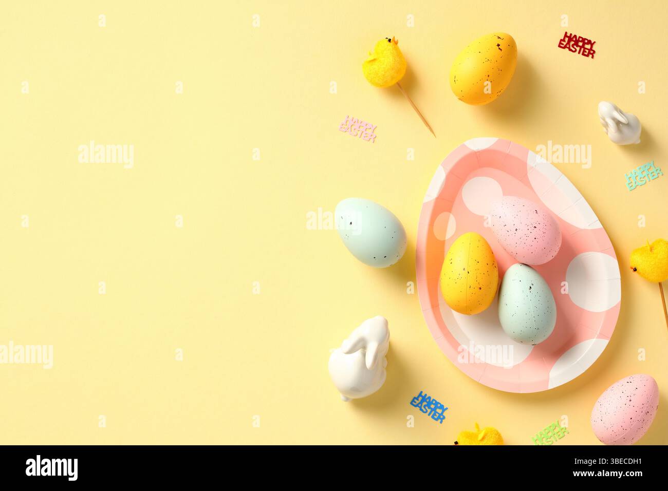Happy Easter banner design. Easter eggs, bunny, decorations on yellow table. Stock Photo