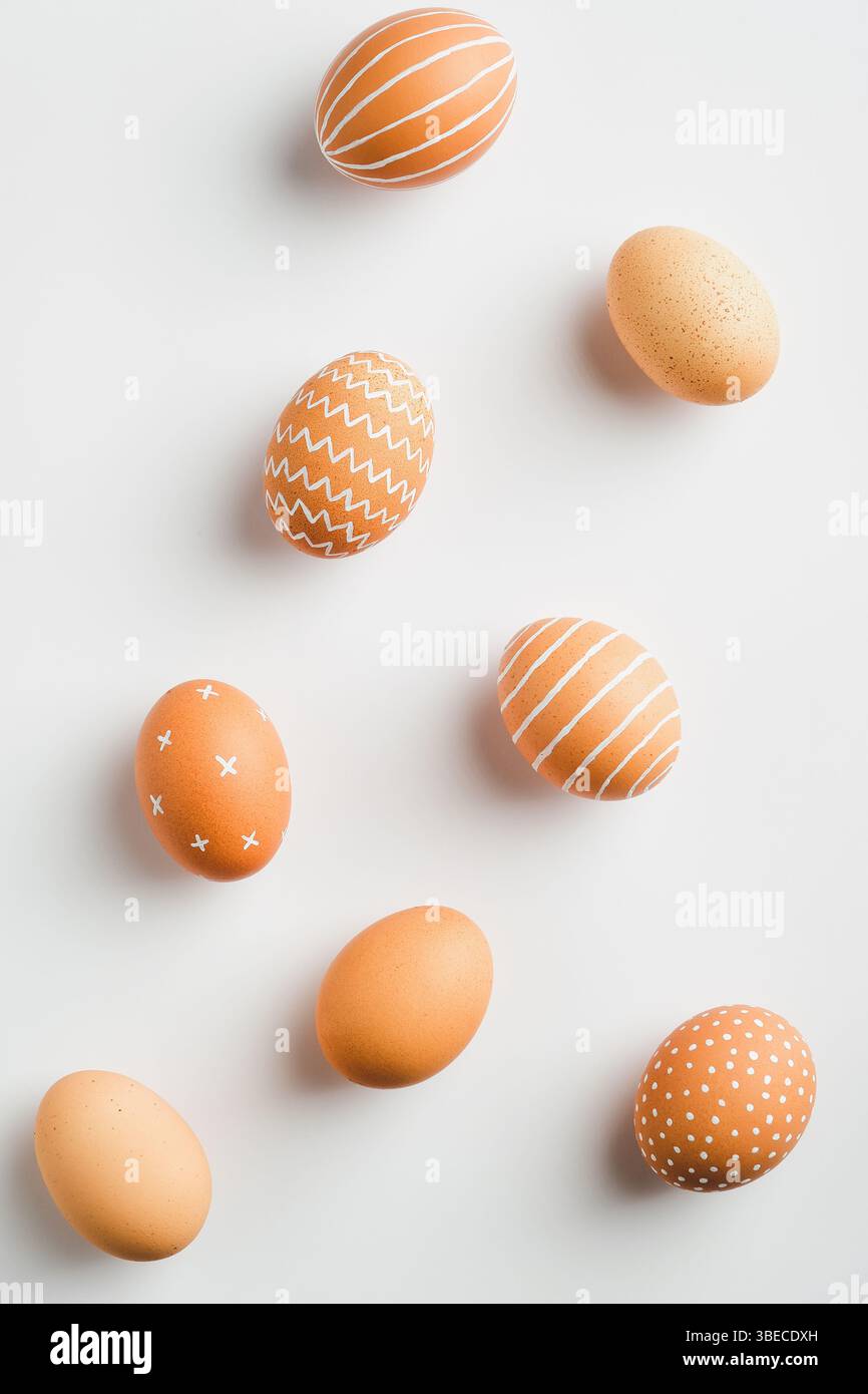 Happy Easter minimal flat lay style composition. Simple Striped and dotted Easter eggs on white background. Stock Photo