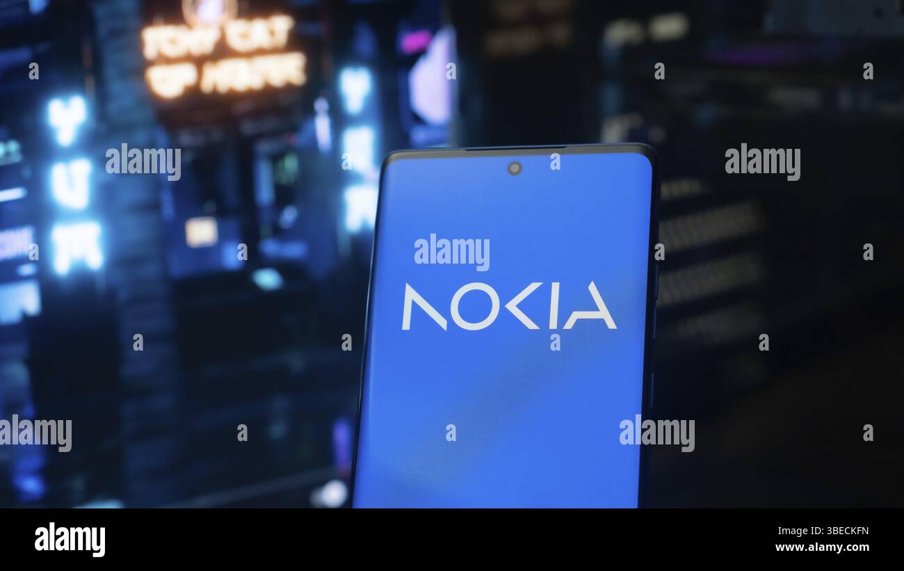 Nokia logo displayed on a smartphone against a neon-lit setting Stock Photo