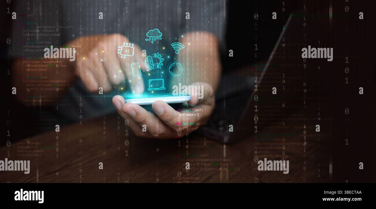 Digital technology and cloud computing: concept. A man using his smartphone and laptop to create, store, process, and communicate information and data Stock Photo