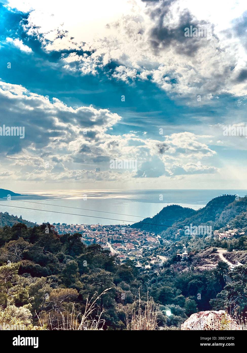 Scenic panoramic view of a coastal city surrounded by hills under a dramatic cloudy sky in Turkey. - Smartphone Captured Stock Image
