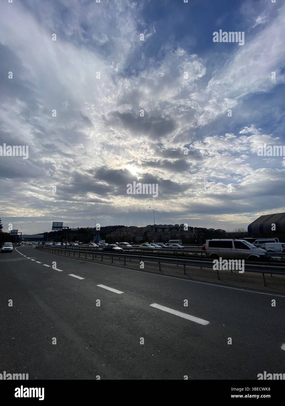 Urban highway scene under a dramatic cloudy sky, with cars and surrounding cityscape in Istanbul. - Smartphone Captured Stock Image