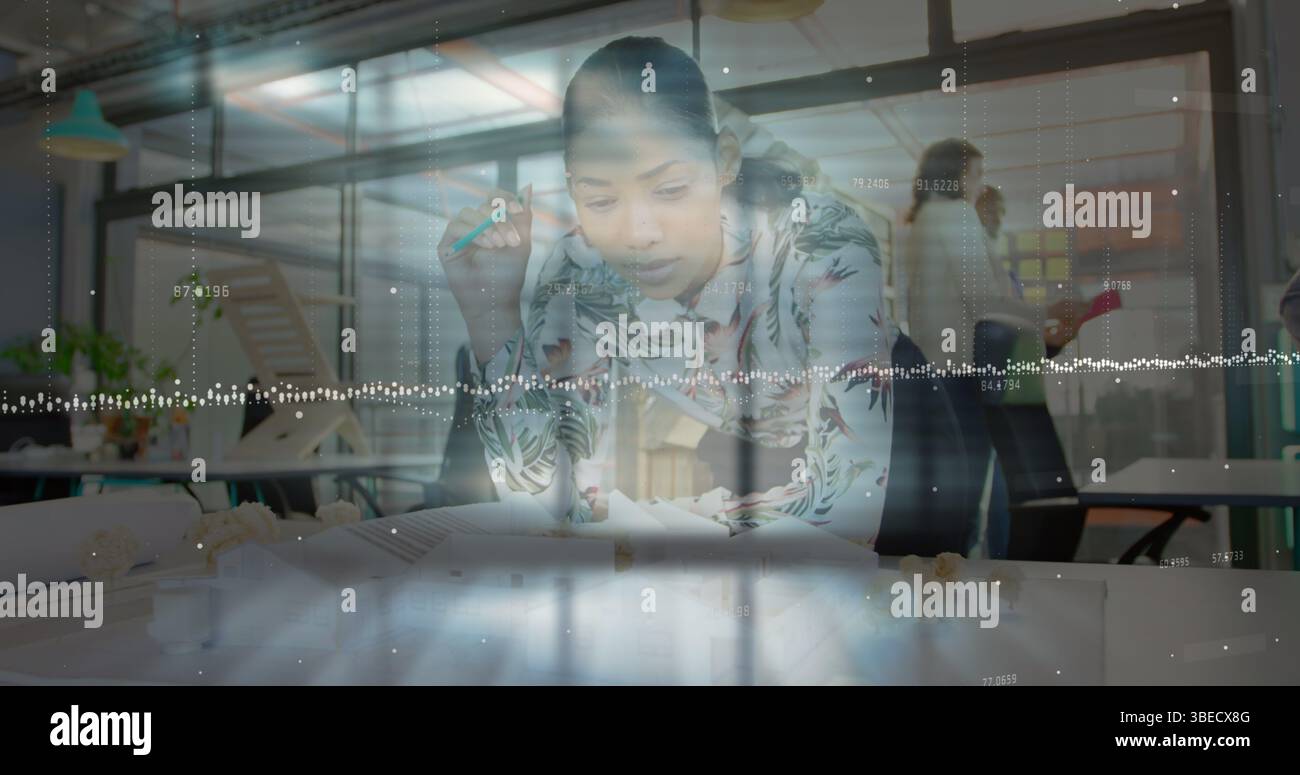 Image ofdata processing against african american female engineer working on her model at office Stock Photo