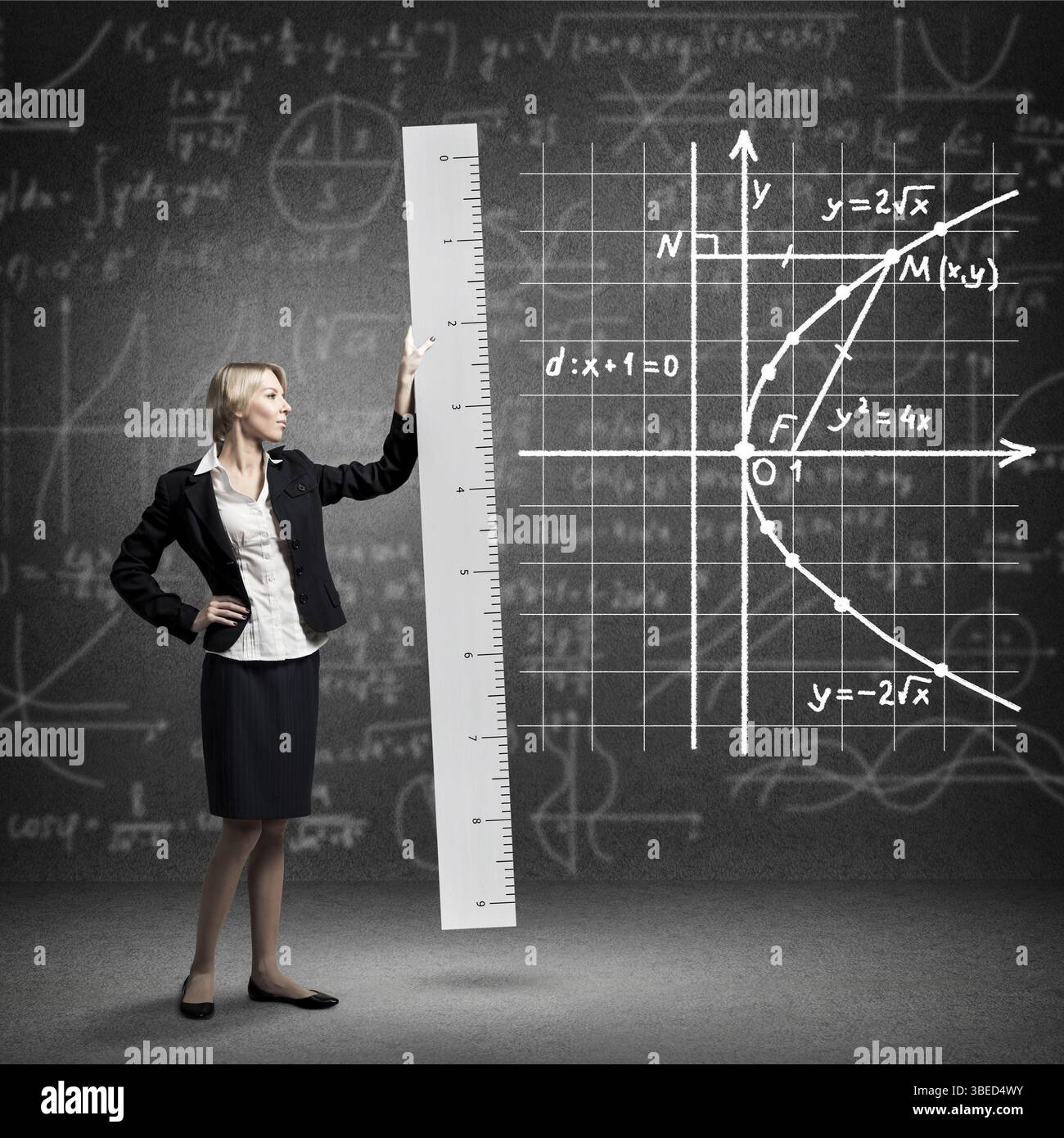 Young mathematics teacher holding big ruler on background chalkboard ...