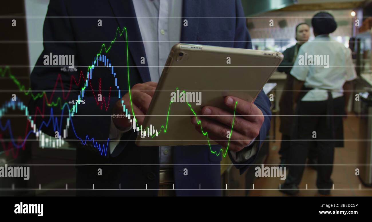 Financial data processing against mid section of manager using digital tablet in restaurant kitchen Stock Photo