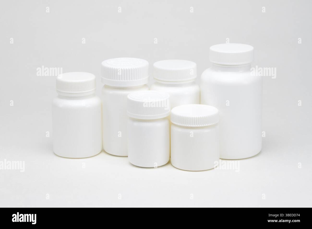 White plastic pill jars on a white background. Isolated Stock Photo