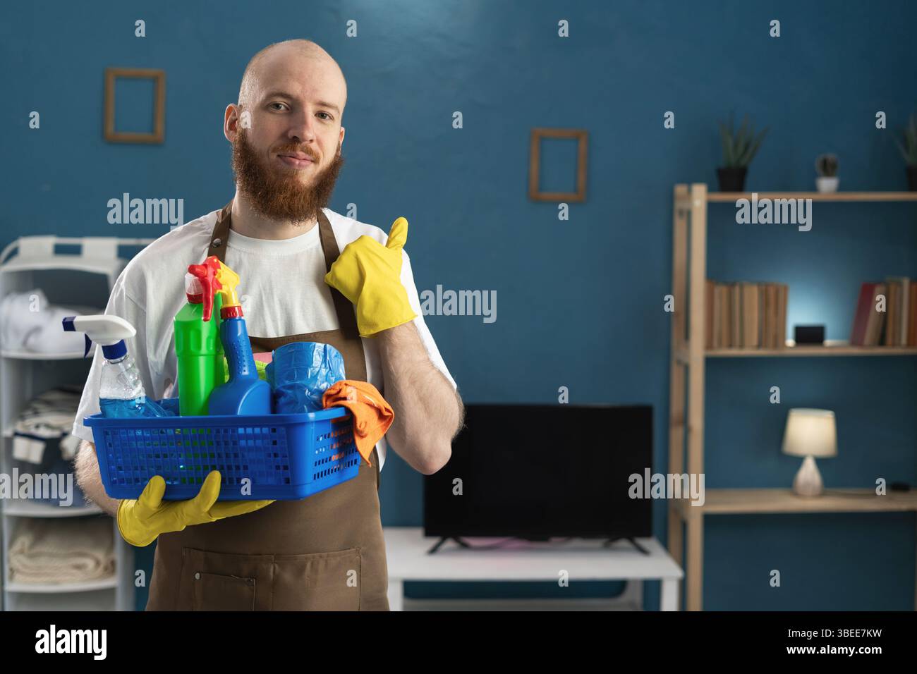 Happy smiling Janitor bearded man wearing apron holding basket with ...