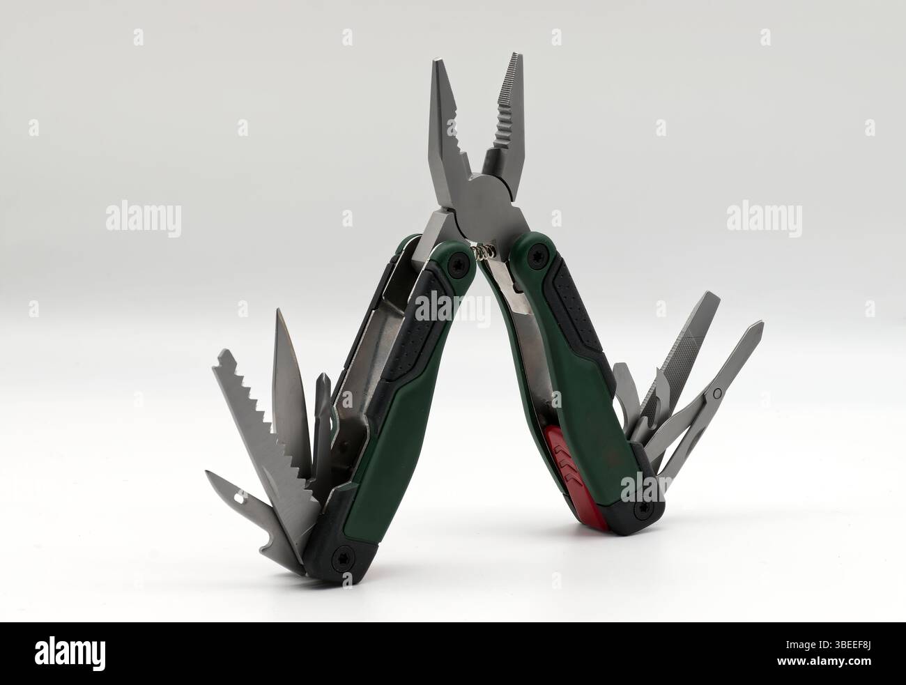 Multi tool with multiple functions and pliers isolated on white. Stock Photo