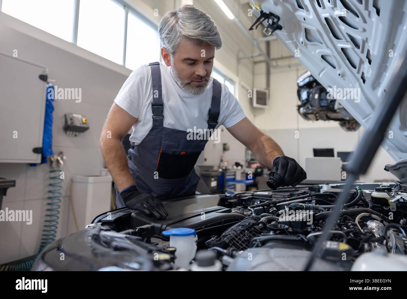 Mechanic checking oil level in engine Stock Photo - Alamy