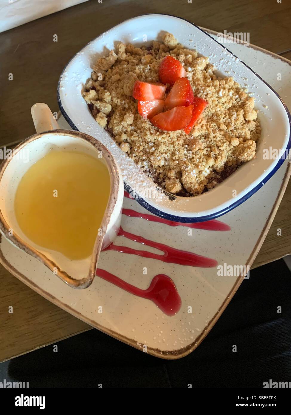 Crumble pie food hungry custard bowl plate strawberries red yellow eat eating restaurant pub look looks tasty nice local village style nice brown eat - Smartphone Captured Stock Image