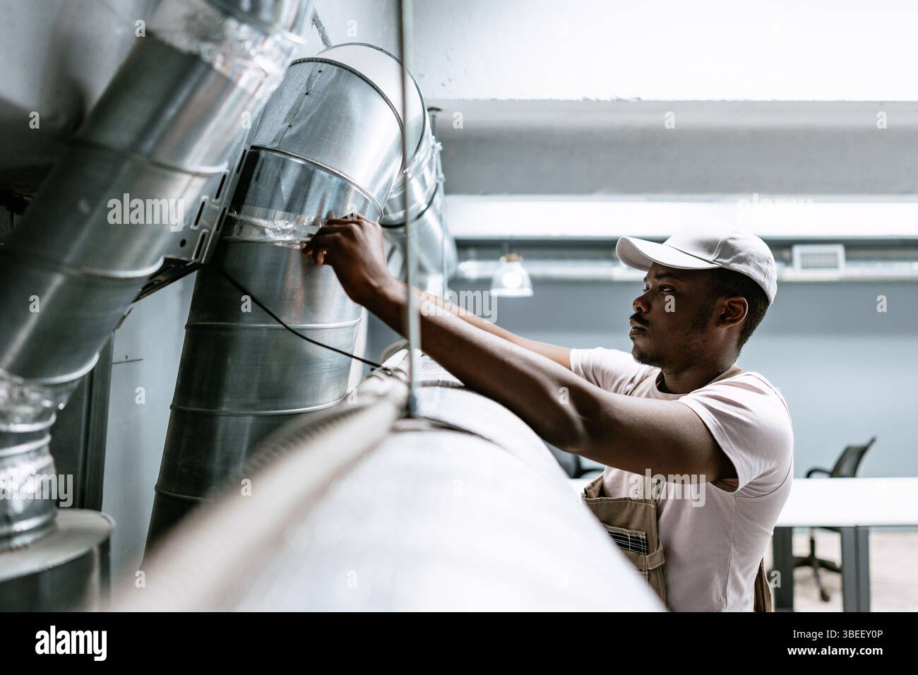 Technician working on ventilation system in modern office during daytime Stock Photo