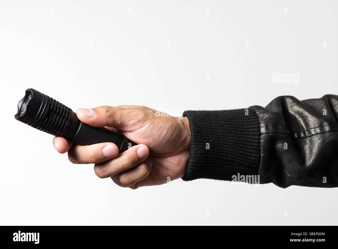 The man holding a LED flashlight in hand. Stock Photo