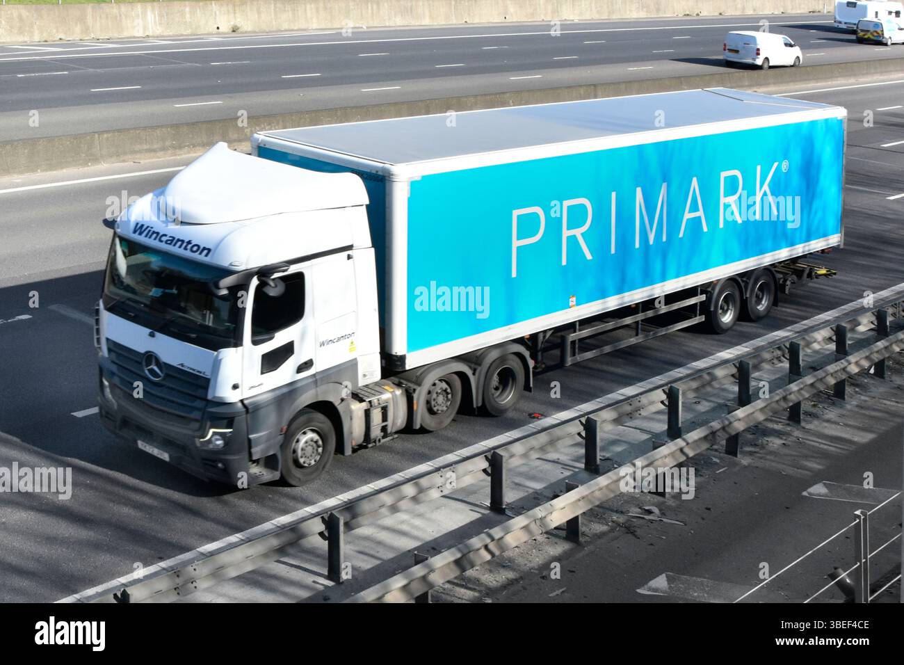 Primark retail business supply chain hgv Mercedes lorry truck & articulated rigid body trailer aerial side front view on M25 Motorway Essex England UK Stock Photo