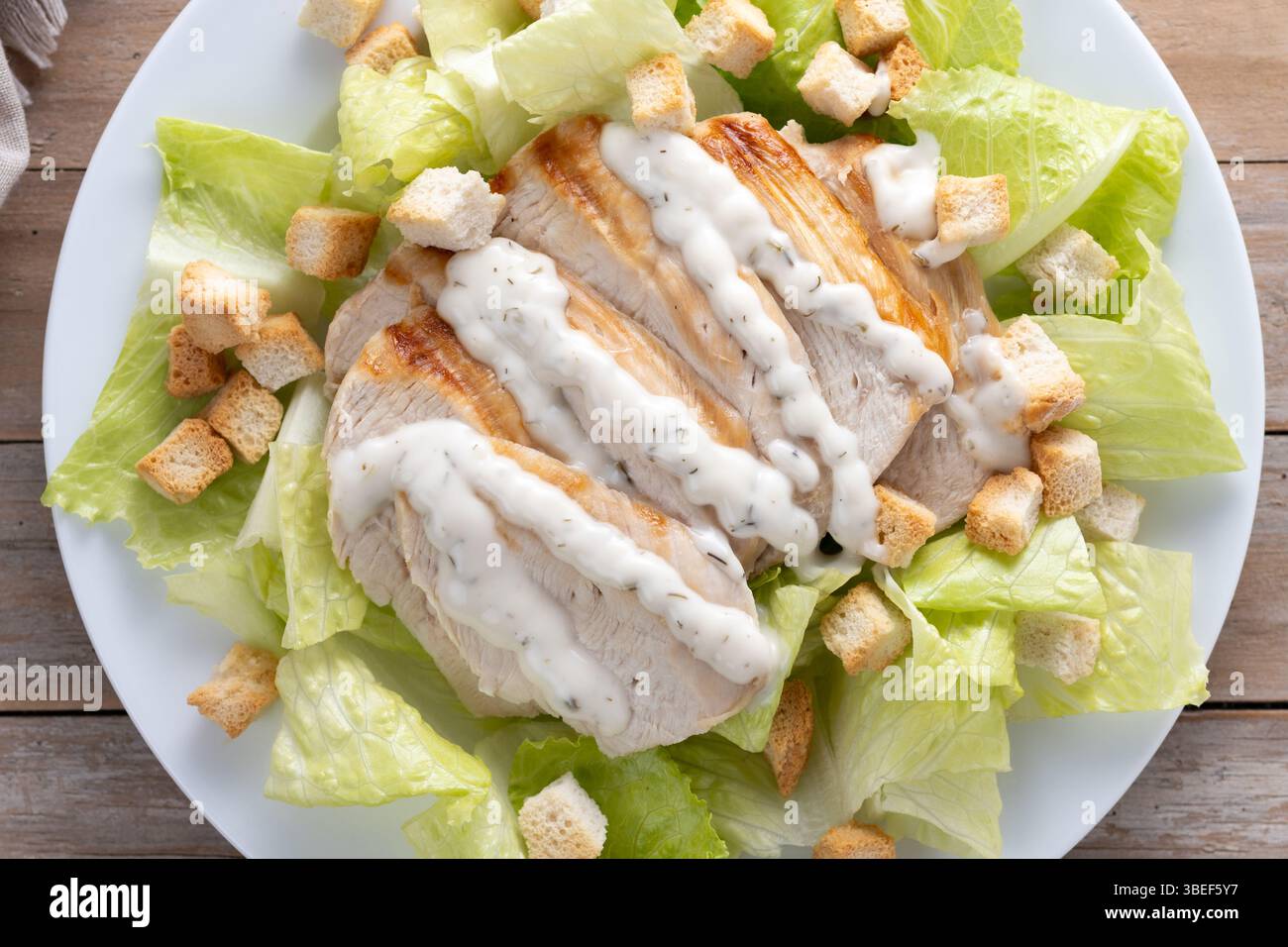 Classic Caesar Salad Fresh and crunchy Caesar salad on black slate background Stock Photo