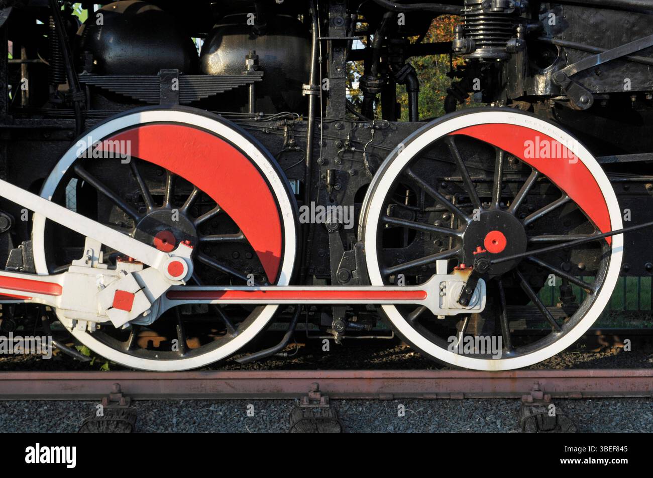 Red and white wheels and piston of an old steam engine train Stock Photo