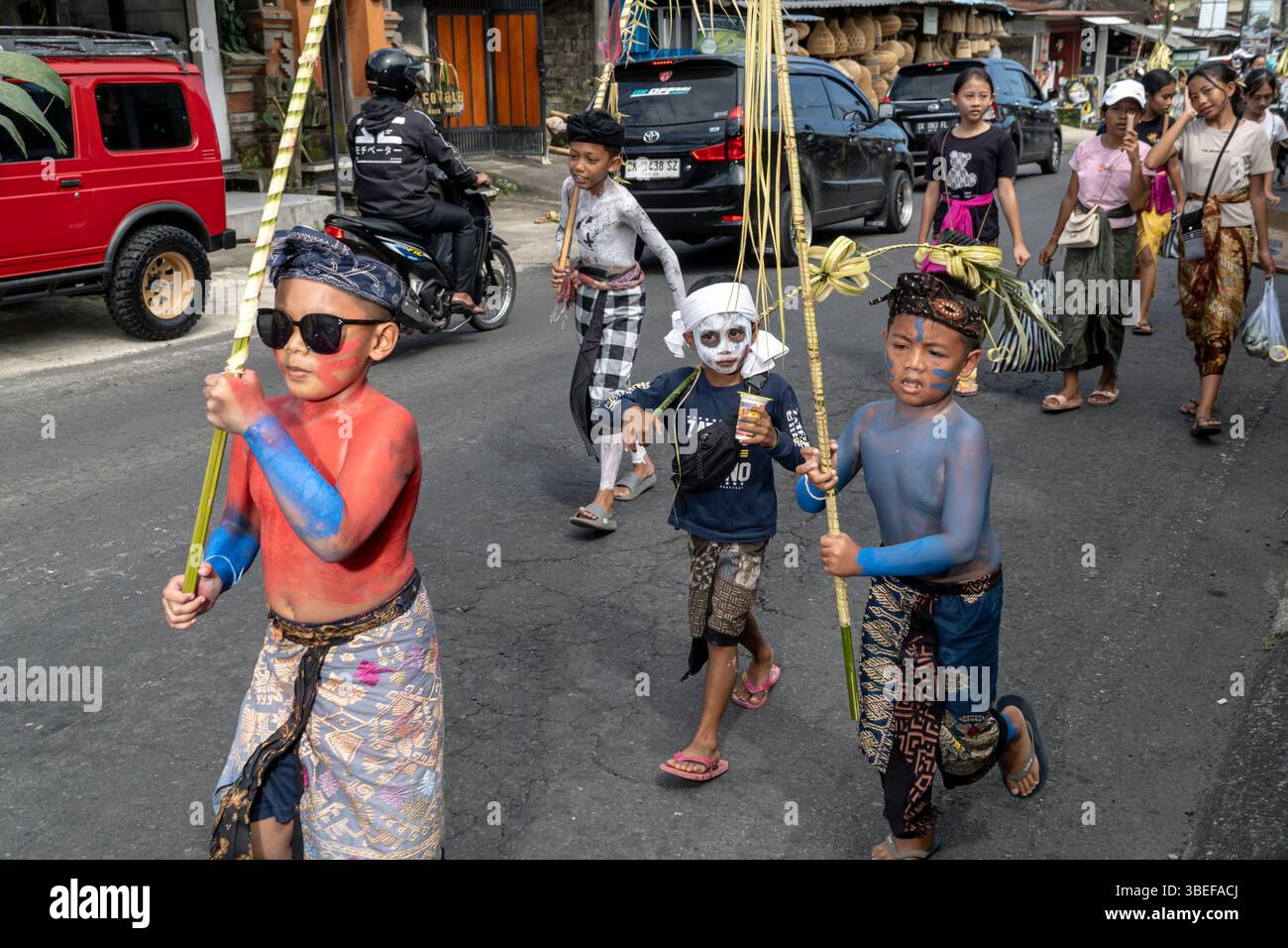 A group of children march around the village during the ritual with ...