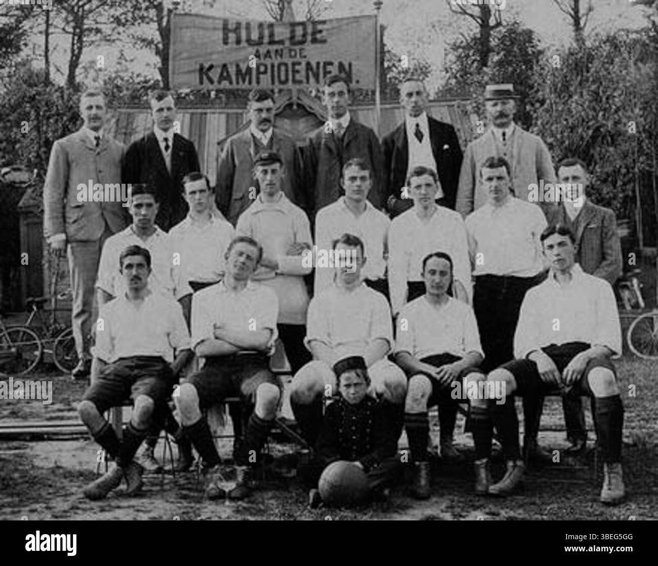This historical photograph showcases the HVV football squad, Dutch football champions of the 1906-1907 season. The image identifies key players including Heijting, Van Oven, and Kessler, as well as the proud club officials. The background features the changing rooms that were later expanded. Stock Photo