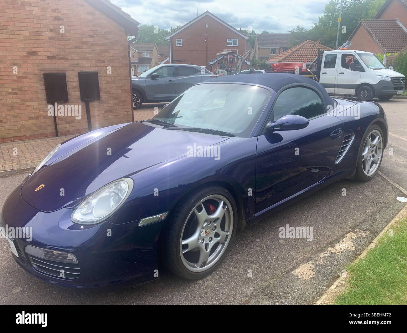 Porsche sports car in blue colour fast speed soft top convertible looks looker posh metallic dream vehicle drive driveway type sporty looker looking - Smartphone Captured Stock Image