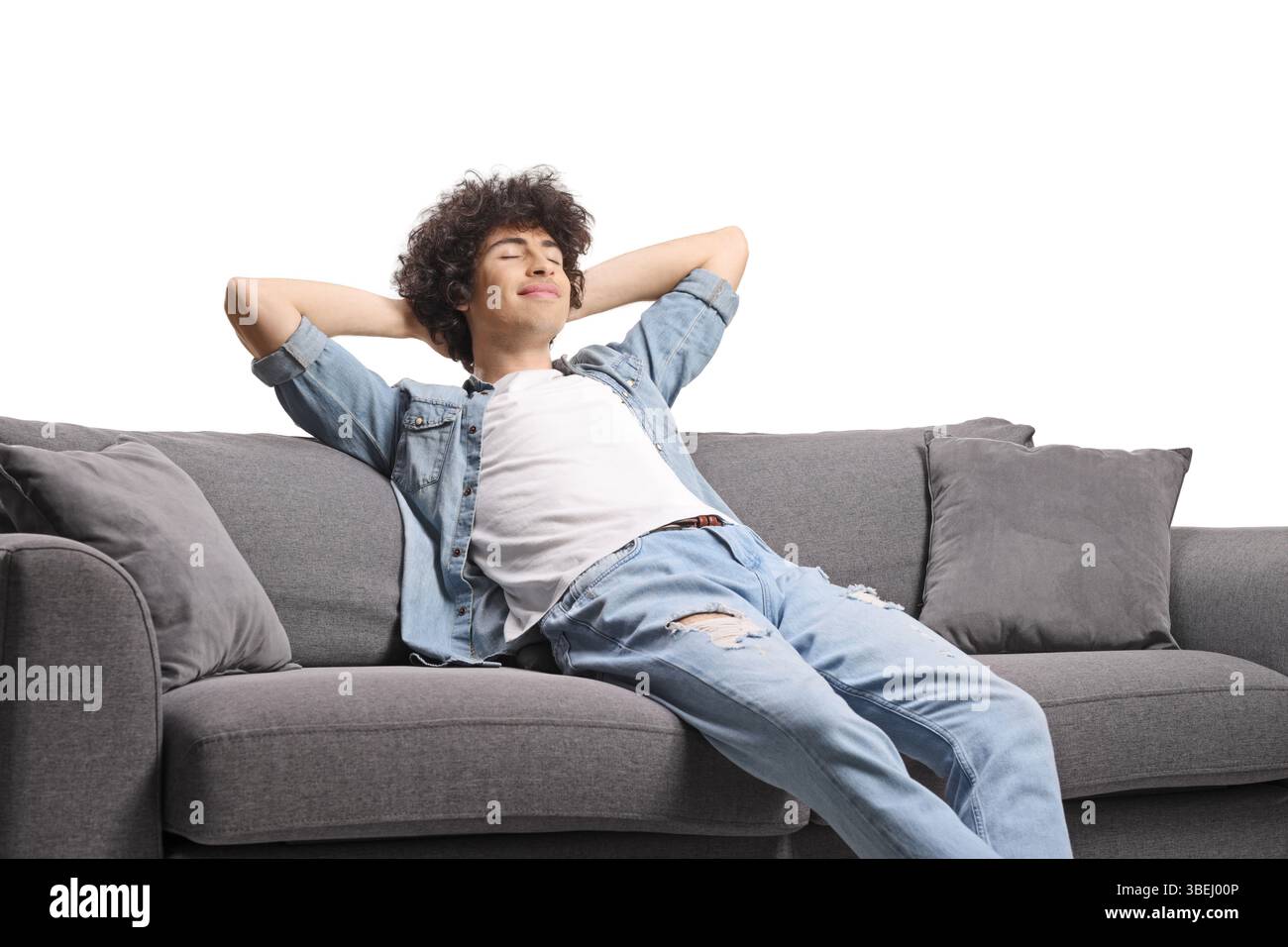 Relaxed young man enjoying on a sofa isolated on white background Stock Photo