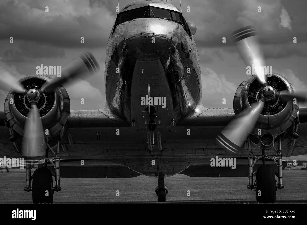 Vintage DC-3 Aircraft with Spinning Propellers on a Cloudy Day in black and white Stock Photo