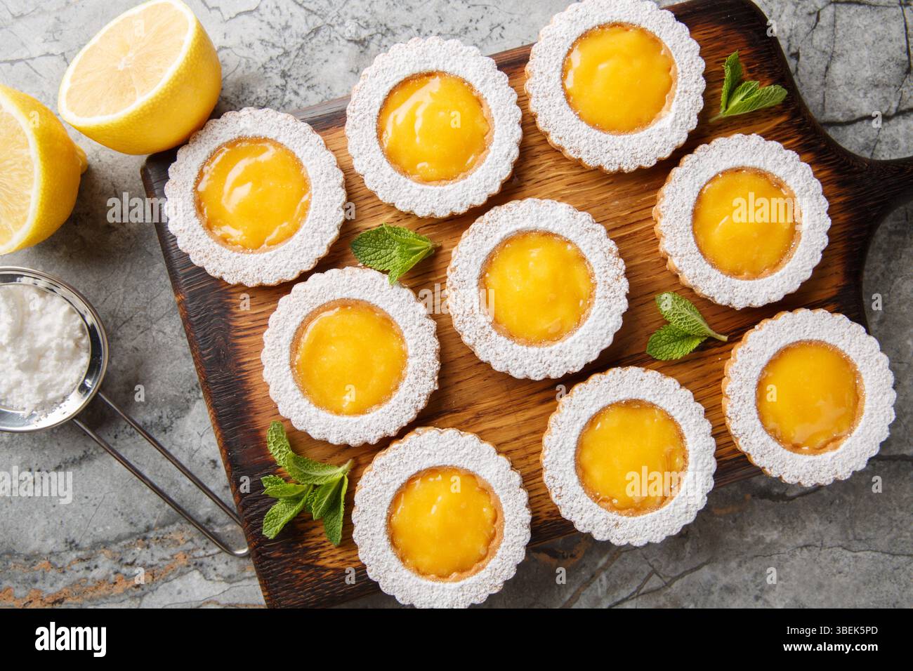 Lemon Curd Cookies feature a soft and buttery lemon cookie filled with a bright citrusy homemade lemon curd closeup on wooden board on the table. Hori Stock Photo