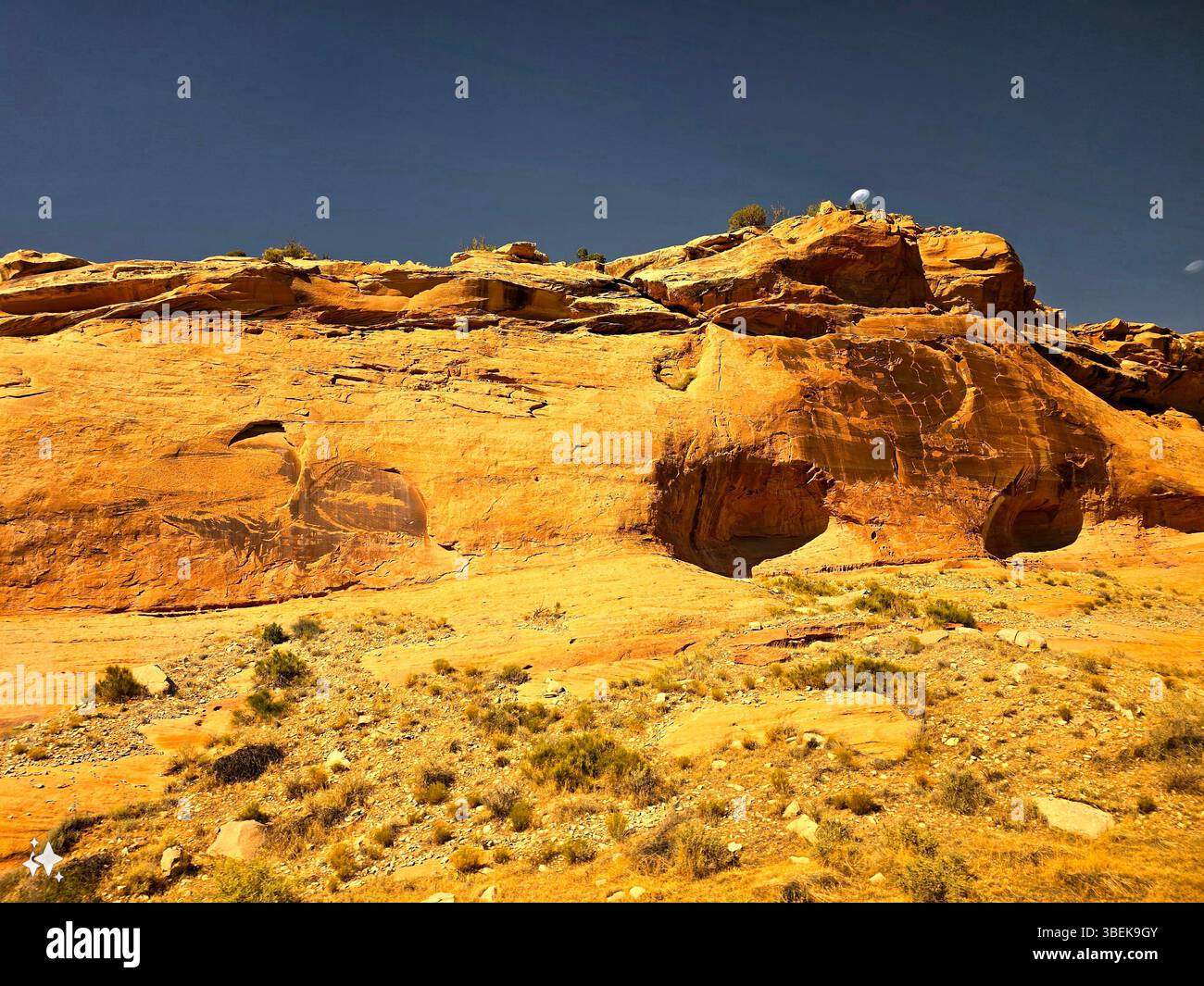 Close-up of layered sandstone ridges, sunlit desert rocks, and sparse vegetation in the rugged terrain of the Utah wilderness, American Southwest. - Smartphone Captured Stock Image