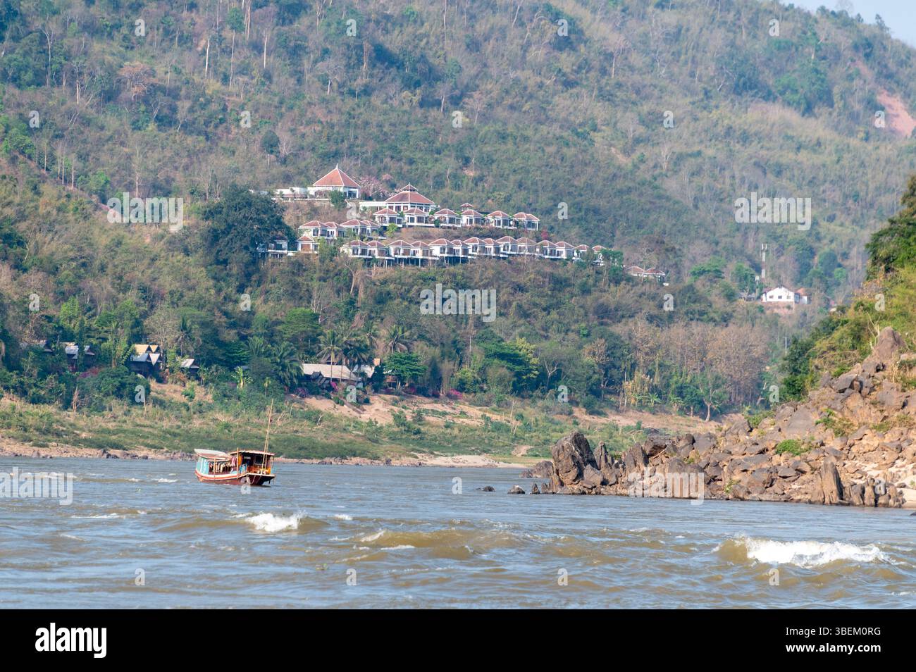 A slow cruiser heading down the Mekong River towards the tourist ...