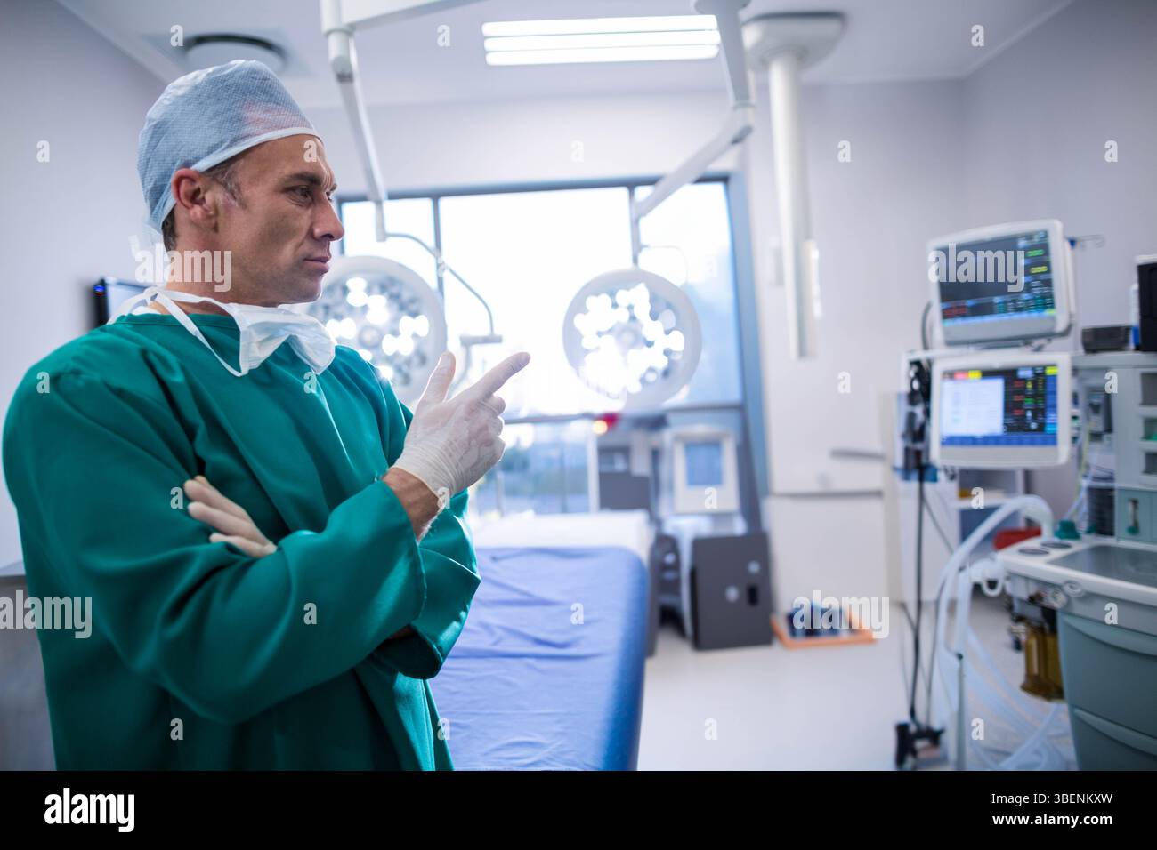 Male surgeon standing beside operating table in operating room checking ...