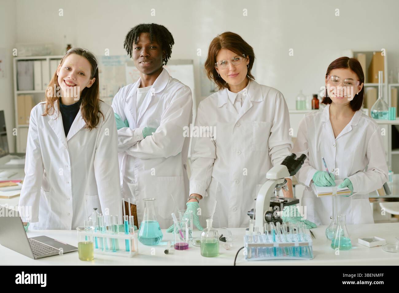 Group of scientists standing in laboratory wearing lab coats and ...