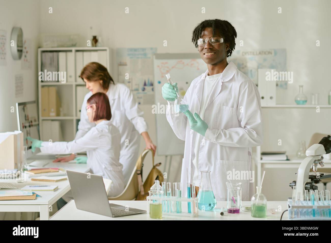 Student working with lab equipment, performing experiment. Two ...