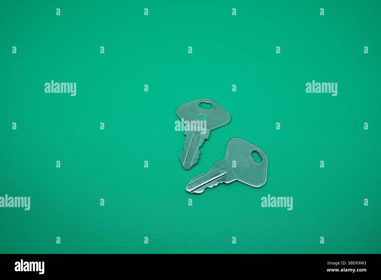 Two pair stainless key isolated on green. Stock Photo