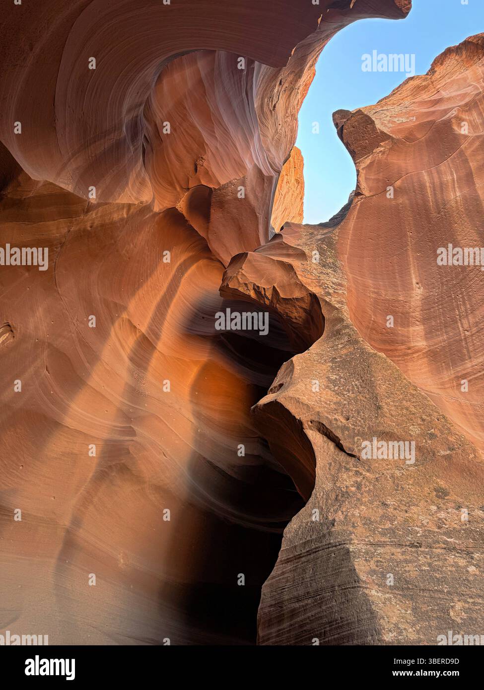 A vertical view of Antelope Canyon’s curving sandstone walls lit by natural light beams in Arizona’s Navajo Tribal Park. - Smartphone Captured Stock Image
