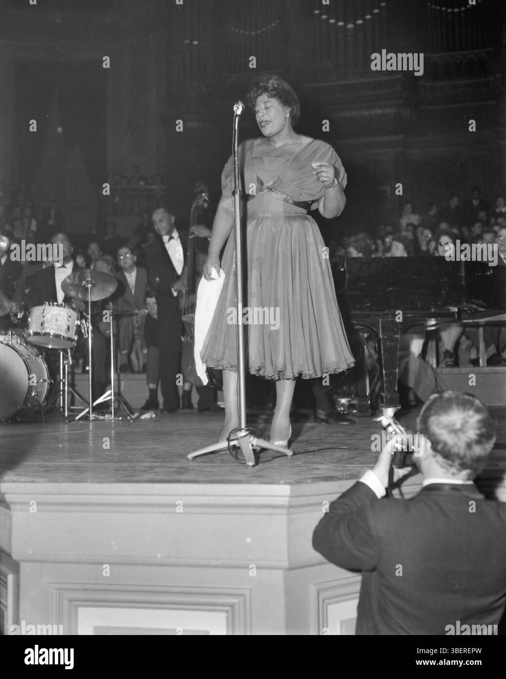 April 11, 1959,  Amsterdam Netherlands. In the series "Jazz at the Philharmonica" in the Concertgebouw, performance by singer Ella Fitzgerald. Ella Fitzgerald singing, behind the piano Lou Levy . Archive Photograph of American Jazz Musicians.  Source: Nationaal Archief Stock Photo