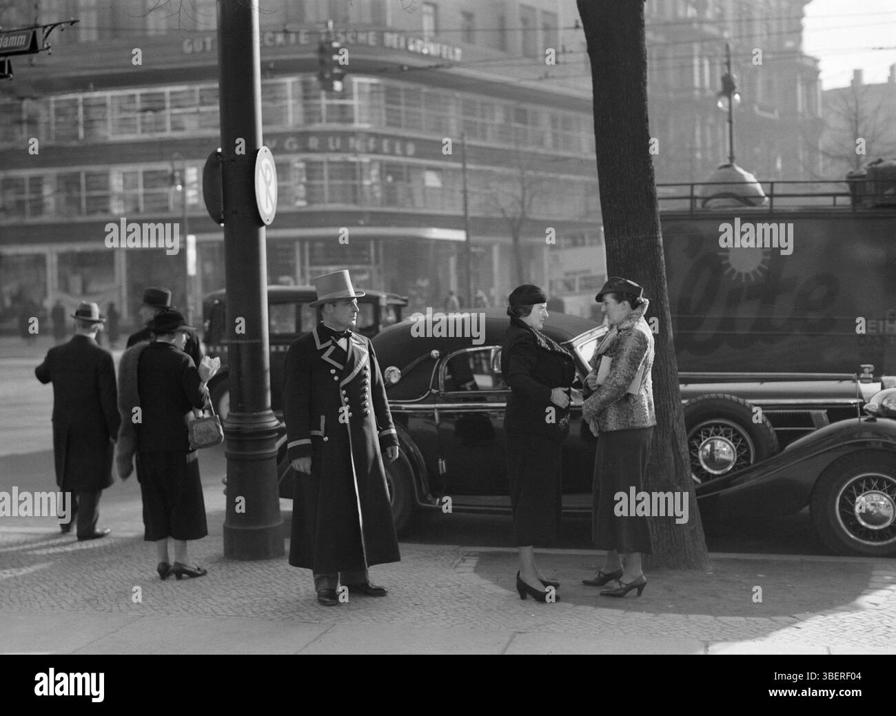 1930s Berlin: Entrance to Cafe Kranzler on the Kurfurstendamm with a doorman in uniform and the linen house K.V. Grunfeld in the background.  1938 .  Archive Photograph of Berlin, Germany,  Photo Credit:  Willem van de Poll Stock Photo