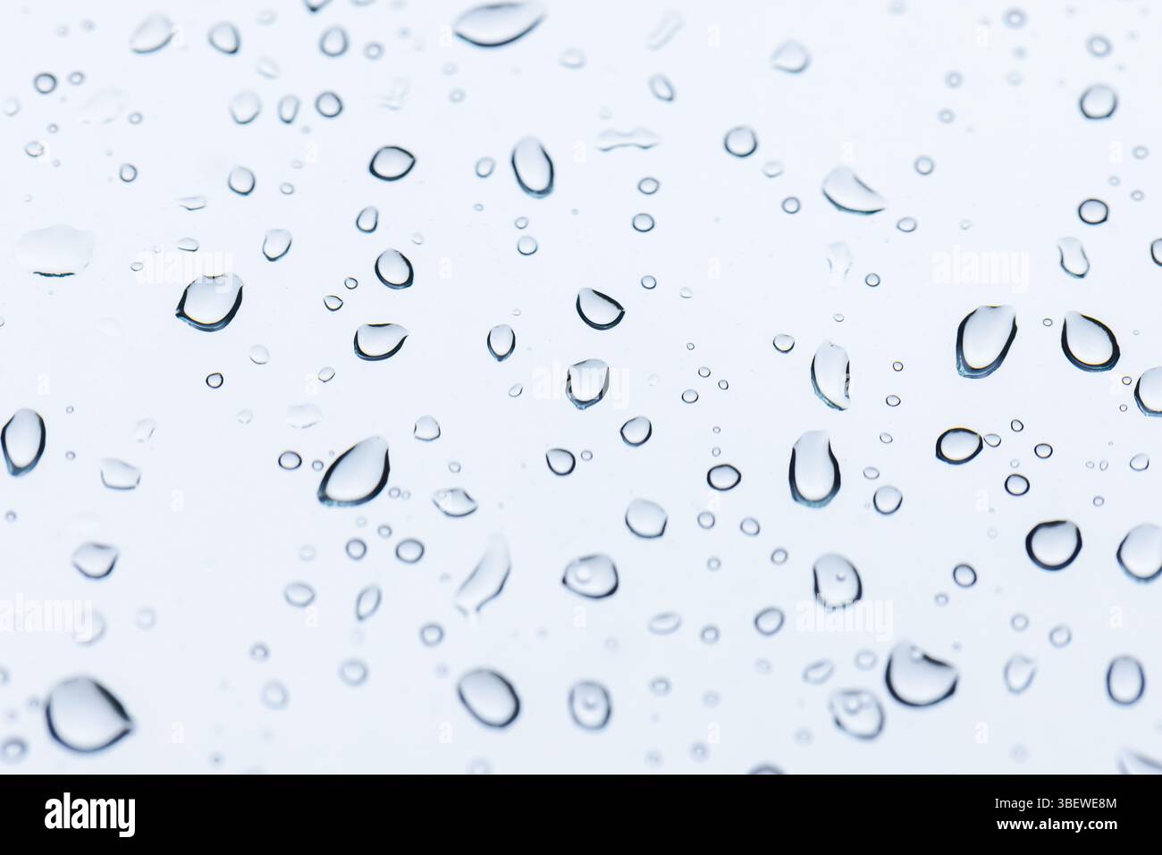 Macro photograph showcasing water droplets on a pristine white surface ...