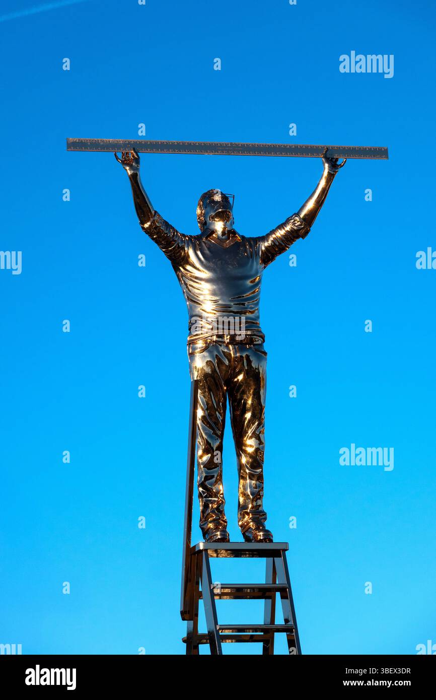 Golden sculpture by Jan Fabre of a man on a ladder holding a ruler, located at Rond-Point Robert Schuman in Luxembourg City, Luxembourg Stock Photo