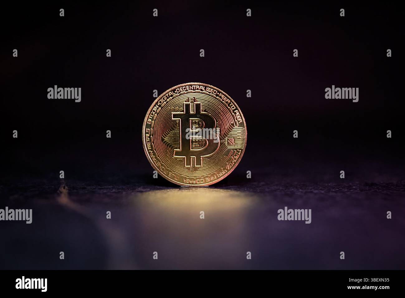 Bitcoin with Golden Glow Reflected on Surface Stock Photo