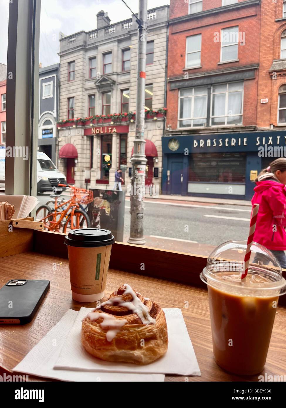 An iced latte, a hot chocolate and a pastry at an aesthetic cafe in a busy city in Dublin, Ireland, United Kingdom, Europe. - Smartphone Captured Stock Image