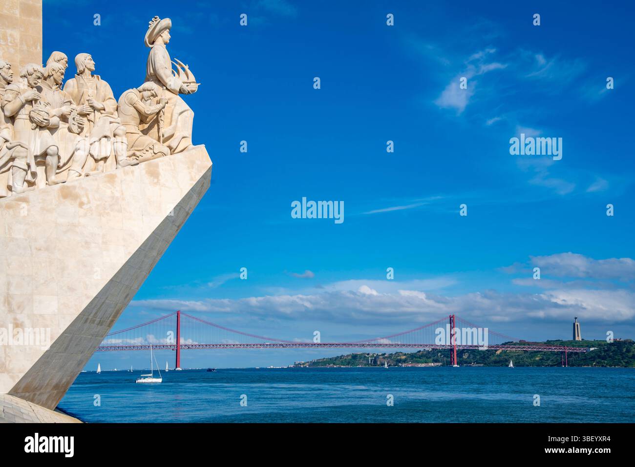 View of Monument to the Discoveries (Padrao dos Descobrimentos) and 25 April Bridge on a sunny day, Lisbon, Portugal, Europe Stock Photo
